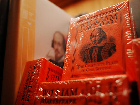 a stack of william shakespeare books on a shelf