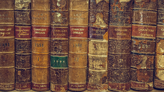 A row of very old, worn-out books on a shelf.